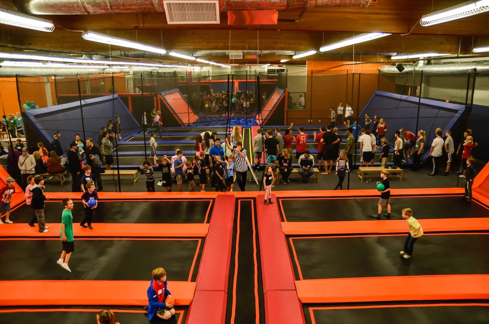 Visitors using connected trampoline courts in an indoor activity venue