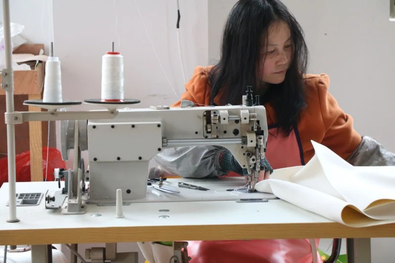 Worker sewing playground upholstery material at an industrial sewing machine